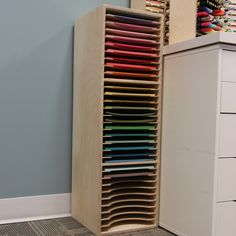 a large stack of colored pencils sits next to a filing cabinet