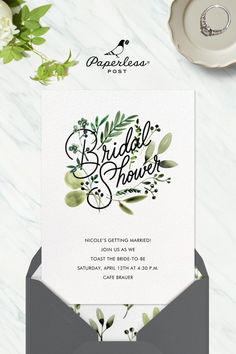 the bridal shower is displayed on top of an envelope with flowers and greenery