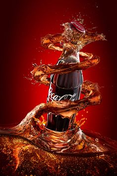 a bottle of coca cola splashing into the water