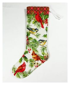 a christmas stocking with red birds and pine cones on it, hanging from a white wall