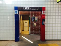 an entrance to a restroom with red, white and blue doors that lead into the bathroom