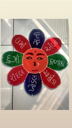 a sunflower with the names of different languages on it's face is shown in front of a tiled floor