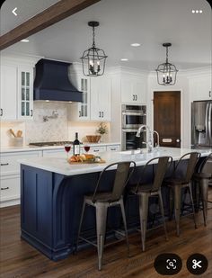 a large kitchen with an island in the middle and chairs at the counter top,