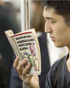 a young man holding up a stack of newspapers