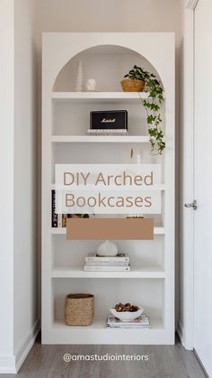 a white bookcase filled with books and plants