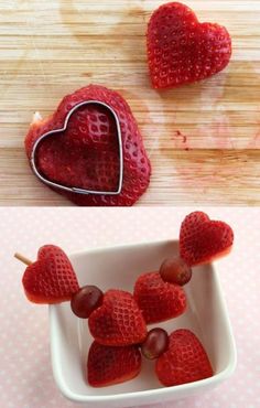 strawberries and grapes are arranged in the shape of a heart