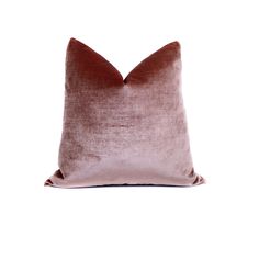 a pink velvet pillow on a white background, with the back turned to reveal a dark brown color