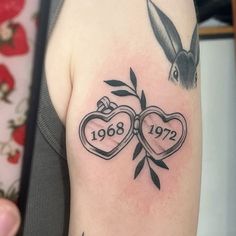 a couple of tattoos on the arm with two hearts and a rabbit behind them that reads 1908