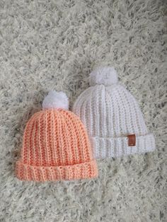 two knitted hats laying on top of a carpet