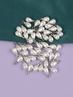 a bunch of white pearls sitting on top of a purple and green table cloth next to each other