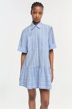 COTTON POPLIN CAPSULE The Cris Dress in Wide Oxford Blue Stripe. Crafted from lightweight fabric, this charming top features a soft blue and white striped pattern that evokes a fresh, summery feel. The shirt dress is designed with a traditional pointed collar and a button-down front that provides a classic touch, while the short sleeves add a casual, airy quality. Blue Stripe Dress, Cotton Poplin Dress, English Factory, Oxford Blue, Lee Cooper, Blue Striped Dress, Poplin Dress, Stripe Dress, Knitwear Tops