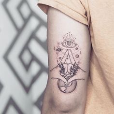 a woman's arm with an all seeing tattoo on it