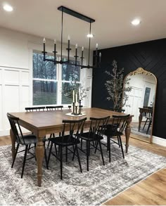 a dining room table with six chairs and a mirror