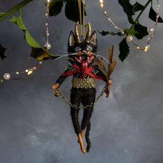 a black cat ornament hanging from a tree