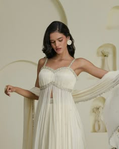 a woman in a white dress is posing with her arms spread out to the side