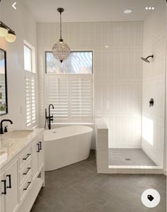 a large white bathroom with an open shower