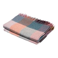 two blankets folded on top of each other with different colors and fringes in them