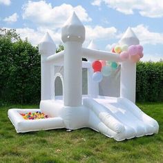 an inflatable bounce house with balloons on the lawn