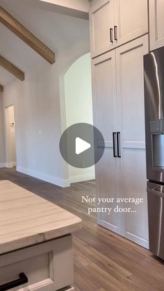 an empty kitchen with stainless steel appliances and wood flooring, not your average pantry door