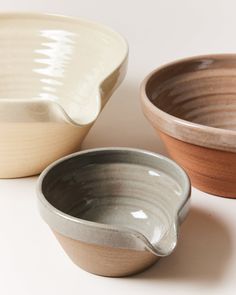 three bowls are shown on a white surface