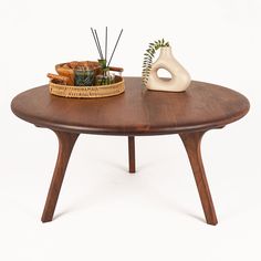 a wooden table topped with a basket and vase