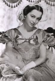 an old black and white photo of a woman in a dress sitting on a chair