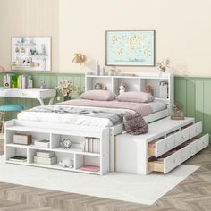 a white bed with drawers underneath it in a room