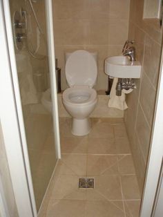 a bathroom with a toilet, sink and shower stall in it's stall door