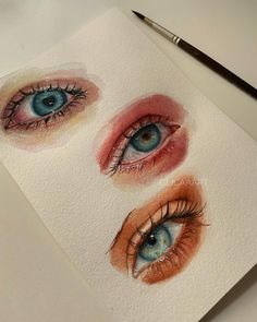 three different colored eyes on top of a piece of paper