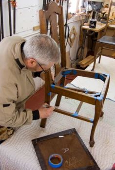 an older man is working on some furniture