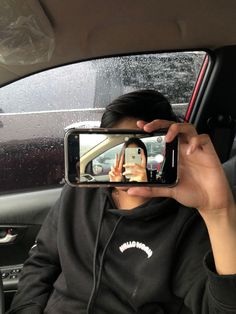 a woman taking a selfie in the back seat of a car with her cell phone