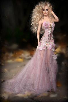 a barbie doll wearing a pink dress with flowers on it's chest and long blonde hair