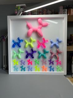 there are many different colored plastic bows in the frame on the counter top and behind it is a shelf with other items