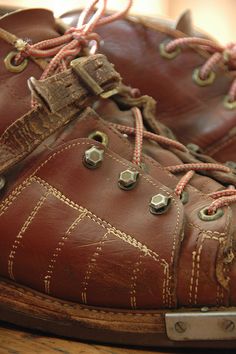 an old pair of brown shoes with laces on them