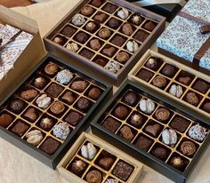 four boxes filled with different types of chocolates