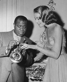 an old black and white photo of two people looking at something in front of them