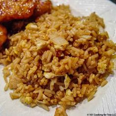 some rice and meat are on a white paper towel with brown sauce in the middle