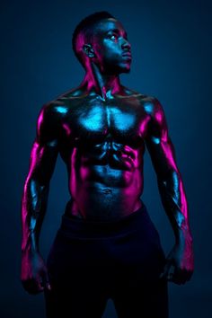 a man with glowing paint on his body and chest, standing in front of a dark background