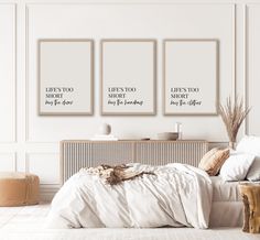 three posters on the wall above a bed in a room with white walls and flooring