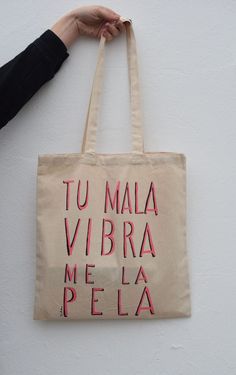 a person holding a tote bag that says tu maia vibra me la pela