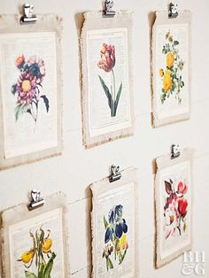 there are many pictures hanging on the wall with flowers in them and one has a clipboard attached to it