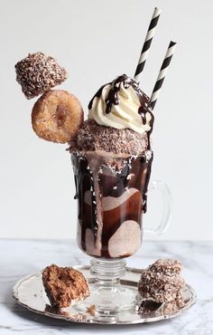 there is a chocolate drink with ice cream and donuts on the table next to it