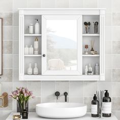 a white sink sitting under a bathroom mirror next to a shelf filled with bottles and soaps