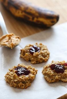 oatmeal cookies with jam on top and a banana in the back ground