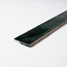 a green piece of wood sitting on top of a white table