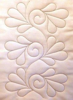 a close up of a white quilt with an intricate design on the front and back