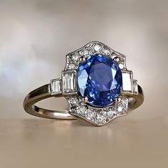 an oval blue sapphire surrounded by baguettes and diamond accents on a white gold ring