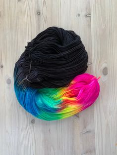 two skeins of yarn with multicolored hair sitting on top of each other