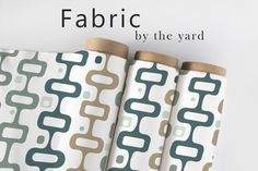 three rolls of fabric sitting next to each other with the words fabric by the yard on them