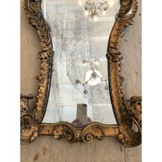 an ornate gold framed mirror hanging on the wall